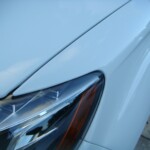 Before and after photographs of a damaged white, AUDI Quattro SUV that was repaired by Elite Paint & Body Shop in West Palm Beach, Florida.